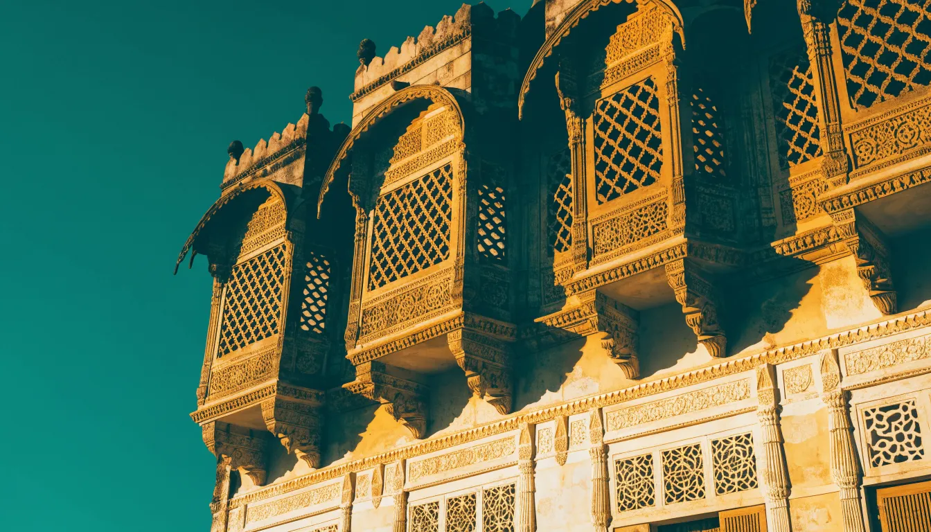 Carved haveli facade in old Gurugram, layered balconies and jharokha windows
